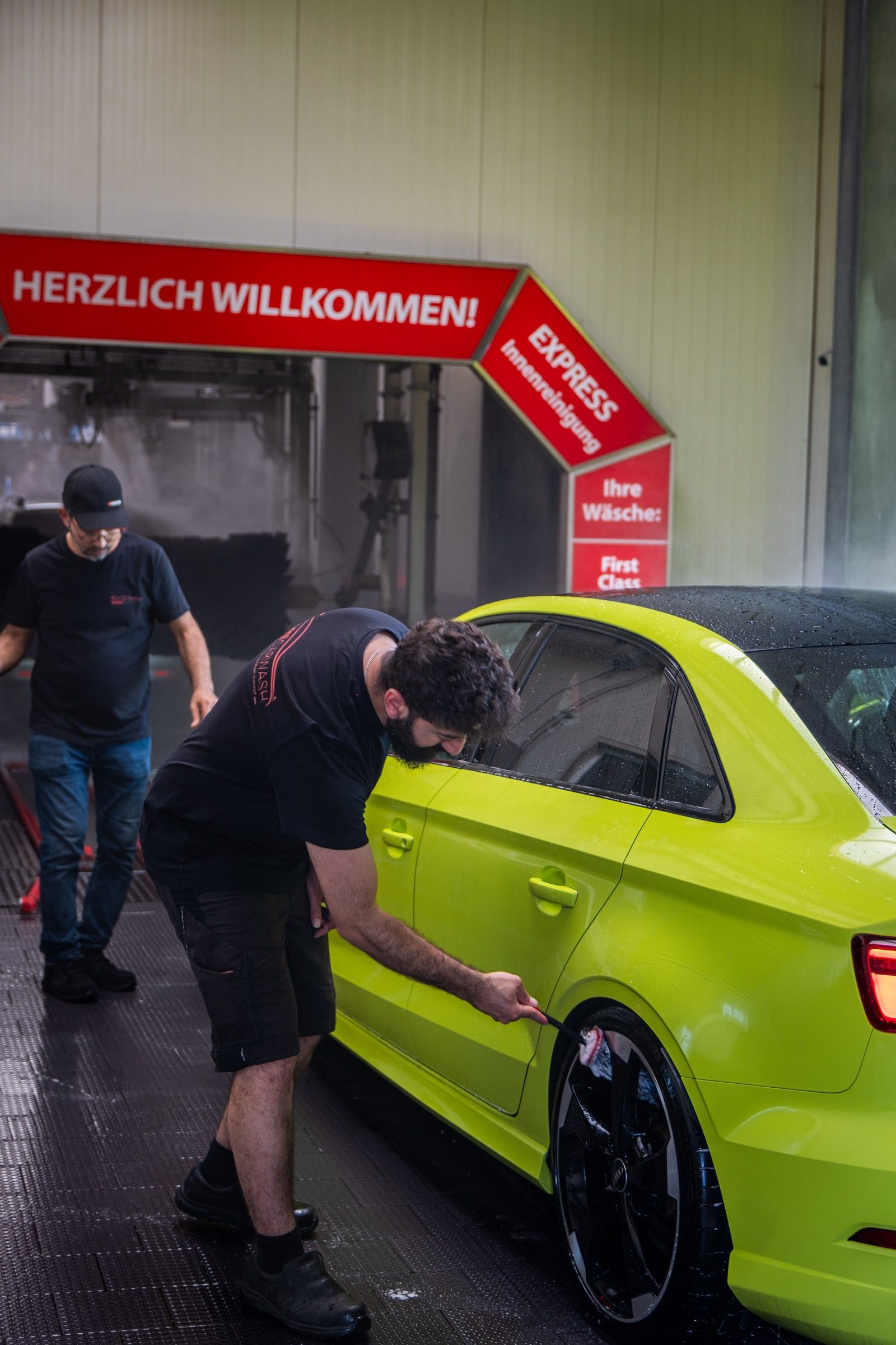 Das Team von emmi Carwash wäscht ein Auto von Hand vor